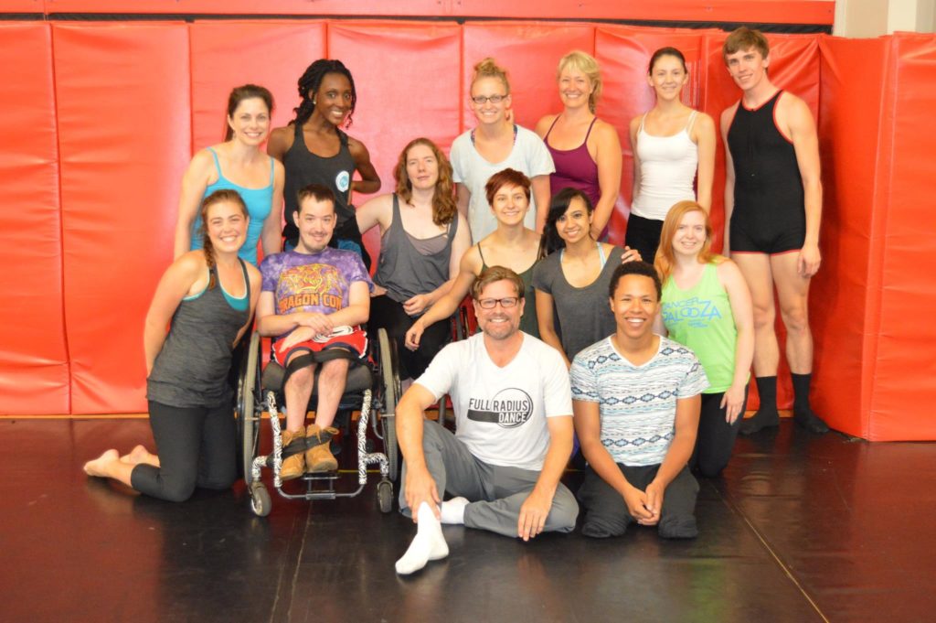 Dancers posing with their dance choreographer, all smiling