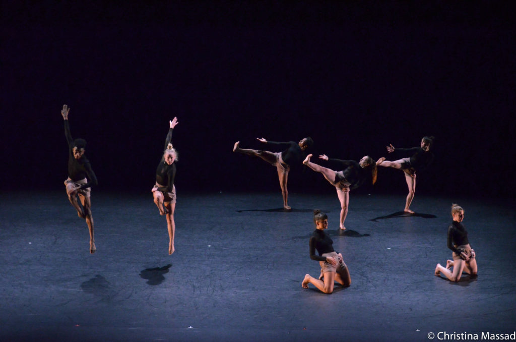 Seven ladies in black dancing attire performing