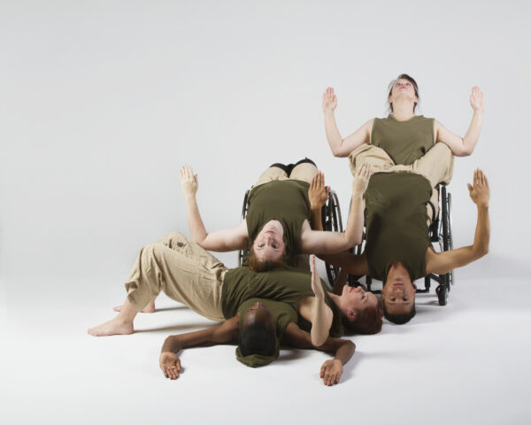 Five dancers in sleeveless hooded tops and mid-length pants form a human puzzle with their bodies.
